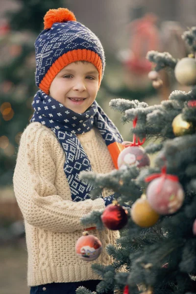 Bela criança da escola, menino, decorando a árvore de Natal em um fros — Fotografia de Stock