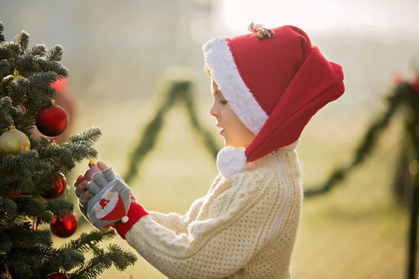 Bela criança da escola, menino, decorando a árvore de Natal em um fros — Fotografia de Stock