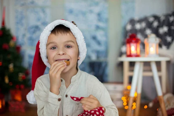 Мила дошкільна дитина, хлопчик, читає книгу і їсть печиво — стокове фото
