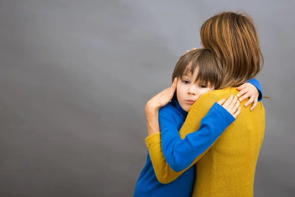 Smutny małe dziecko, chłopiec, przytulanie w domu, jego matka na białym tle imag — Zdjęcie stockowe