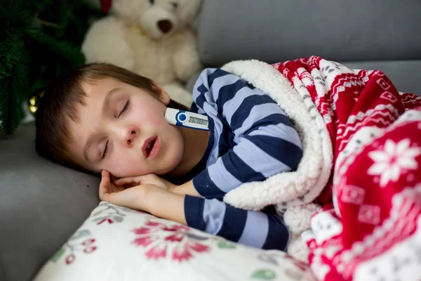 Beteg kis gyerek, a fiú, és alszik a kanapén, a magas láz — Stock Fotó