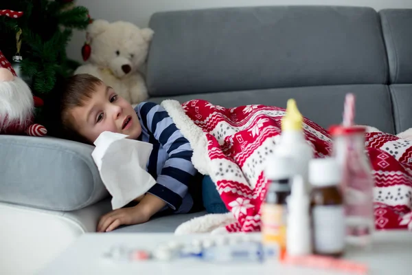 Niño enfermo, chico, con fiebre alta durmiendo en el sofá en — Foto de Stock