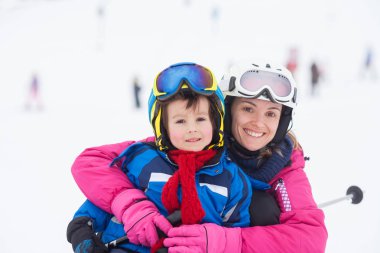Tatlı genç çocuk ve annesi hafif bir kayak öğrenme, sl Kayak