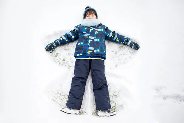 Petit enfant doux, garçon, couché sur la neige du pôle nord, faisant de la neige un — Photo