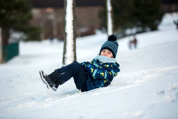 Schattig kind, jongen, sliding met bob in de sneeuw, winter — Stockfoto