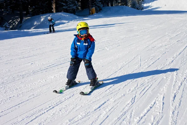 Menino bonito, esquiando feliz na estância de esqui austríaca no mo — Fotografia de Stock