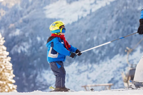Lindo niño, esquiando felizmente en la estación de esquí austriaca en el mo —  Fotos de Stock