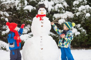 Mutlu güzel çocuklar, kardeşler, Bina kardan adam bahçe içinde bir