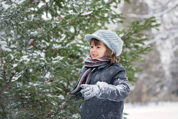 Счастливый малыш, мальчик, играет на свежем воздухе в снежном парке — стоковое фото