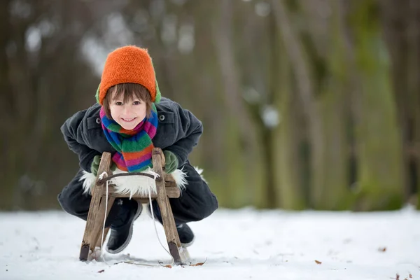 Szczęśliwy, małe dziecko, chłopiec, bawiąc się na zewnątrz w snowy park — Zdjęcie stockowe