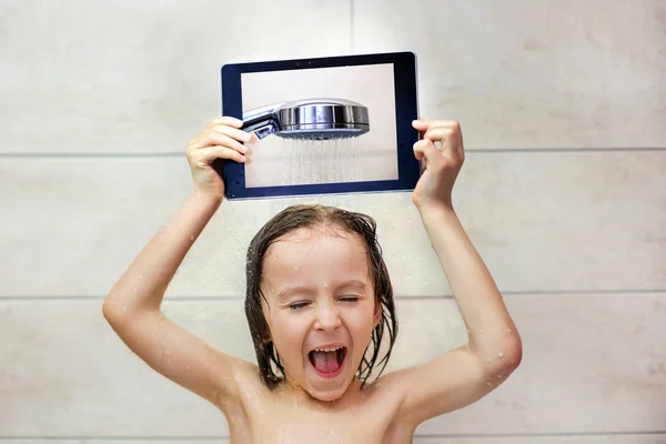 Criança bonito, segurando comprimido, tomando banho — Fotografia de Stock