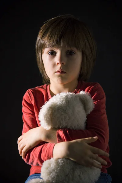 Trauriges kleines Kind, weint, umarmt Kuscheltier — Stockfoto