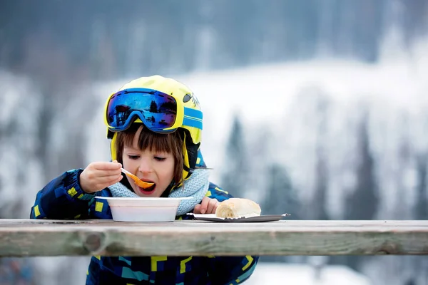 Dulce niño preescolar, comiendo sopa en un restaurante en la pista de esquí — Foto de Stock