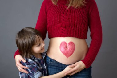 Güzel okul öncesi çocuk, hamile annesi sarılma