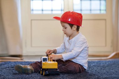 Evde plastik tarak ile oynayan çocuk,