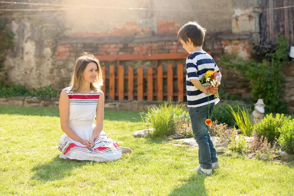 Schattige kleine jongen, geven aanwezig is om zijn moeder voor Moederdag — Stockfoto