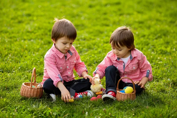 Two boys in the park, having fun with colored eggs for Easter — Stock Photo, Image