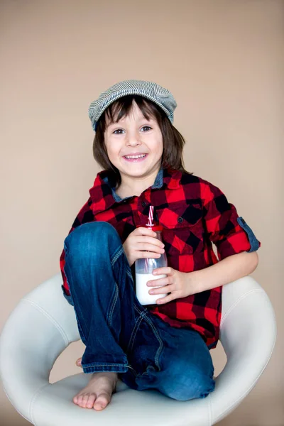 Menino pré-escolar pequeno na moda bonito, bebendo leite de b — Fotografia de Stock