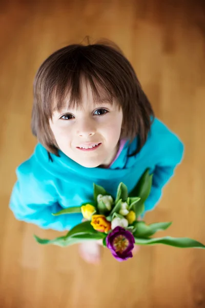 Niño pequeño, sosteniendo ramo de tulipanes —  Fotos de Stock