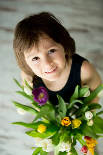 Klein kind, holding boeket tulpen — Stockfoto