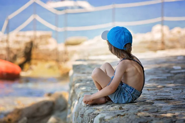 Mignon garçon, assis sur une jetée dans la mer Méditerranée sur rivie française — Photo