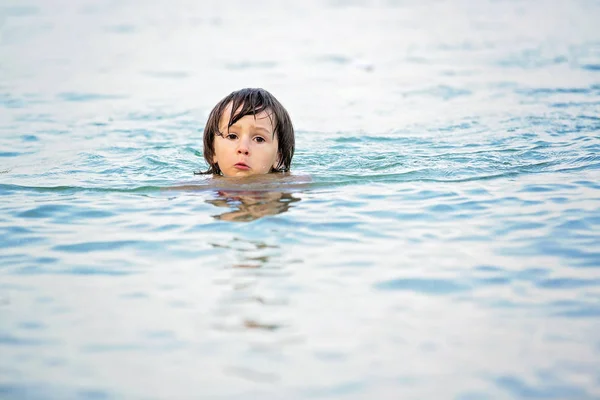 Μικρό χαριτωμένο αγόρι στην παραλία στο νερό, κολύμπι — Φωτογραφία Αρχείου