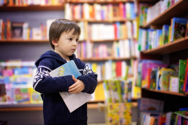 Adorable little boy, sitting in a book store