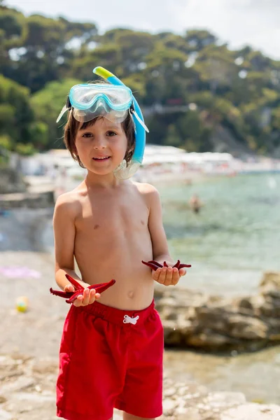 Μικρό αγόρι εκμετάλλευση κόκκινο πέντε σημείου αστερίες στα χέρια του για την — Φωτογραφία Αρχείου