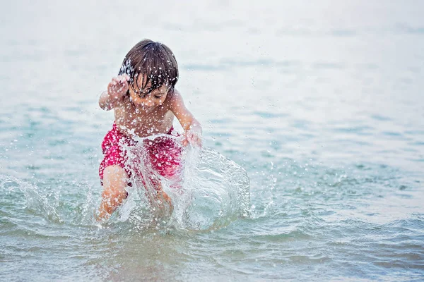Niño lindo en la playa en el agua, nadando — Foto de Stock