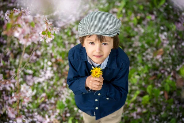 Hermoso retrato de un niño preescolar joven sosteniendo la flor —  Fotos de Stock