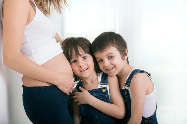 Беременная мать, обнимает детей, задний свет — стоковое фото