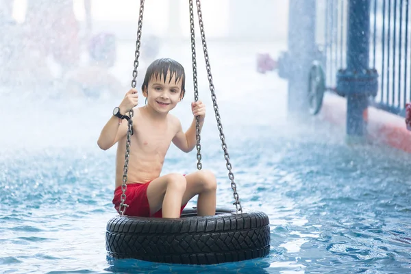 Doce criança, menino, brincando no parque aquático do mundo, desfrutando em — Fotografia de Stock