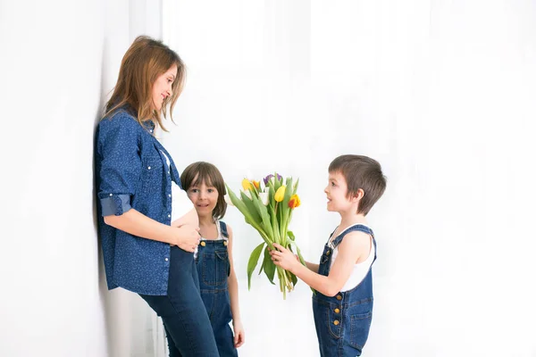 Zwangere moeder, haar kinderen, tulpen, bloemen ontvangen knuffelen — Stockfoto