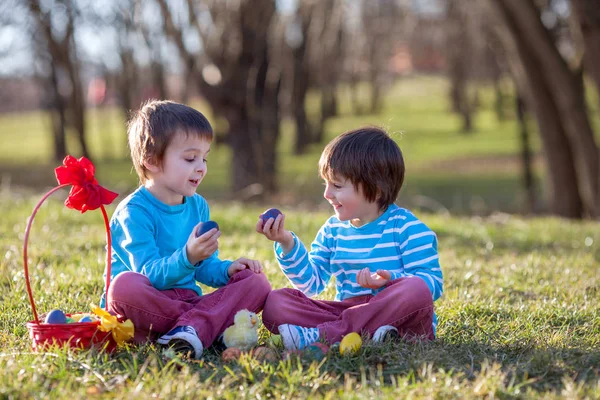 Dos chicos en el parque, divirtiéndose con huevos de colores para Pascua —  Fotos de Stock