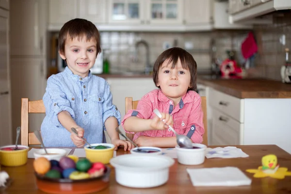 Два мальчика, раскрашивают яйца на Пасху — стоковое фото