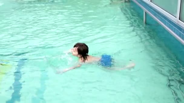Sweet child, boy, swimming with his father in a big swimming pool on a holiday — Stock Video