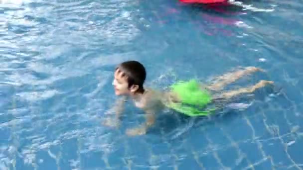 Dulce niño, niño, nadando en una gran piscina en unas vacaciones — Vídeo de stock