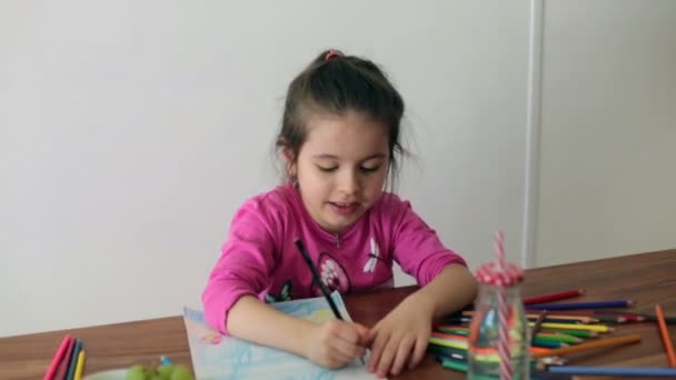 Schattig klein meisje, tekening van foto met potloden thuis, die gelukkig lachend — Stockvideo