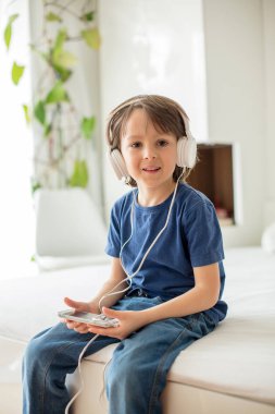 Sevimli çocukla telefon ve baş telefon, müzik dinleme