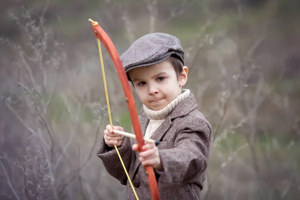 Menino pré-escolar adorável, atirar com arco e flecha no targe — Fotografia de Stock