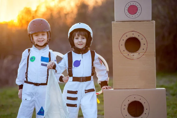 Zwei entzückende Kinder, die im Park bei Sonnenuntergang spielen, angezogen wie ein — Stockfoto