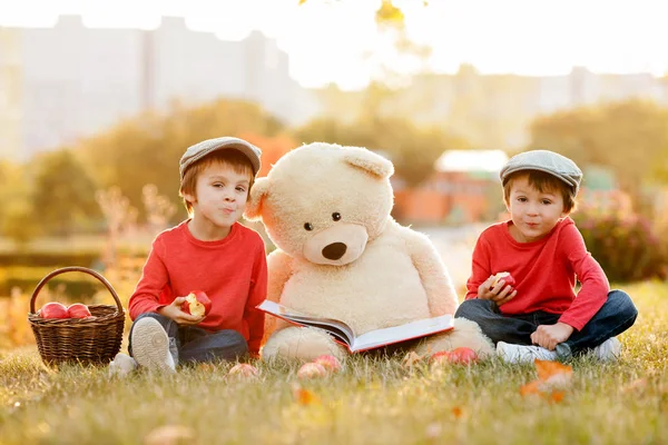 Dos adorables niños pequeños con su amigo oso de peluche en el parque — Foto de Stock
