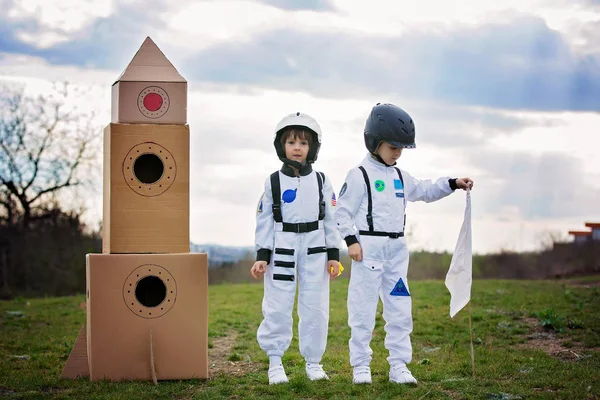 Zwei entzückende Kinder, die im Park bei Sonnenuntergang spielen, angezogen wie ein — Stockfoto