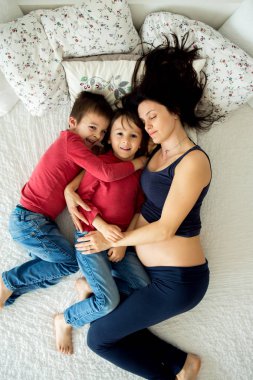 Güzel hamile genç anne ve çocuk, çocuk, lyign yatakta