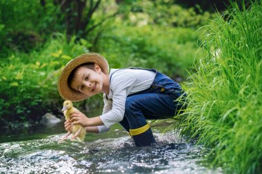 Ördek yavrusu ile little Nehri üzerinde oynayan tatlı çocuk