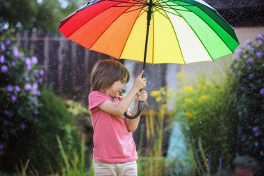 S altında renkli şemsiye ile oynayan sevimli sevimli çocuk, çocuk,
