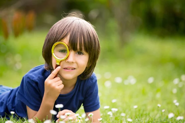 Schöne glückliche Kind, Junge, Erkundung der Natur mit Lupe gla — Stockfoto