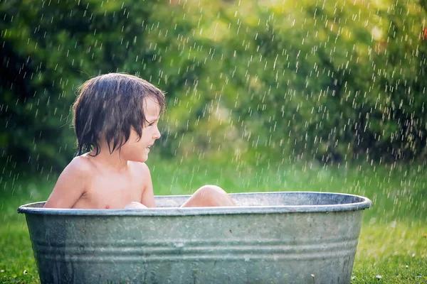 Criança bonito, menino, tendo um banho ao ar livre, fazendo bolhas de sabão — Fotografia de Stock