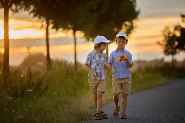 Twee kinderen, een jongen de broers, met plezier buiten met speelgoedauto 's — Stockfoto