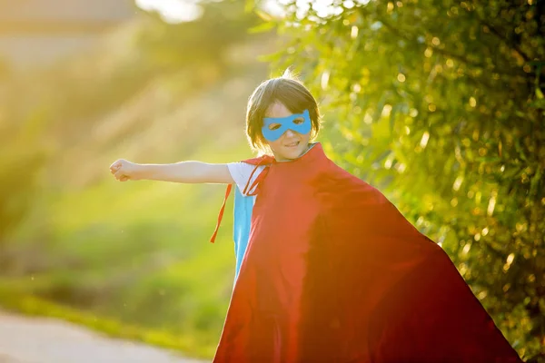 Carino dolce bambino in età prescolare, ragazzo, giocare a supereroe su un r — Foto Stock